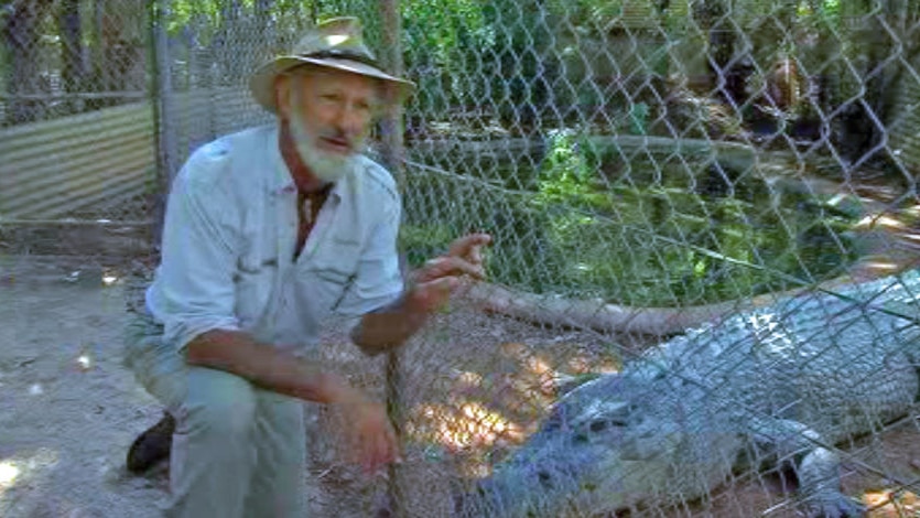 Malcolm Douglas kneeling next to a crocodile