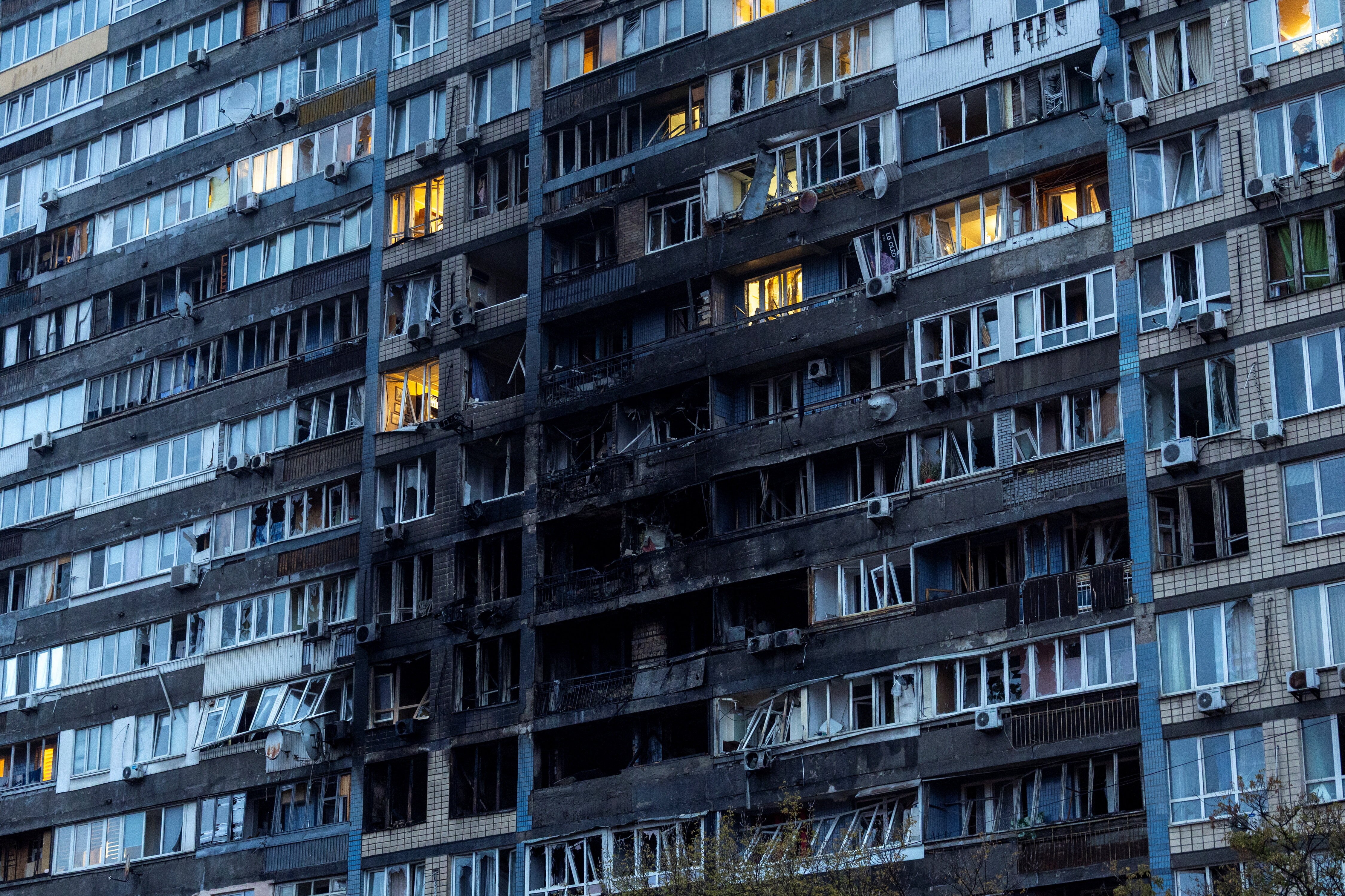 A large Soviet-era apartment block with a large part of its facade burnt out.
