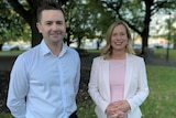 A man and a woman stand next to each other in a park