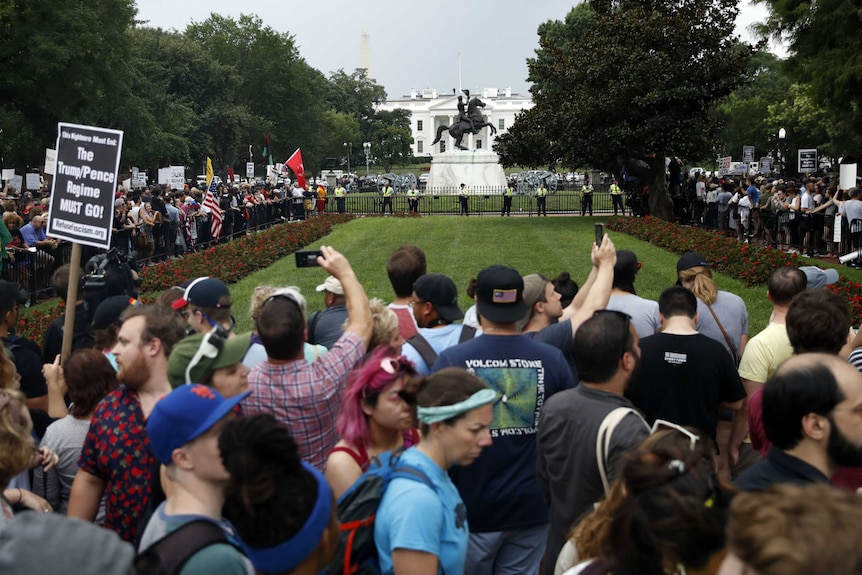Demonstrators line up outside the White House to protest against the Unite the Right rally