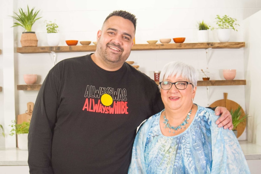 Dane Simpson and mum Lee Simpson stand behind a bench in the kitchen.