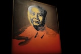 A cameraman stands in front of a painting Mao by US pop artist Andy Warhol.