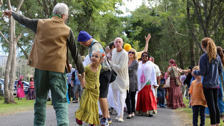 People hold hands in Hare Krishna parade
