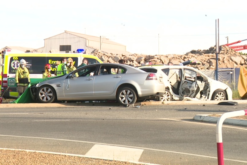 A crash between a sedan and a hatchback with an ambulance