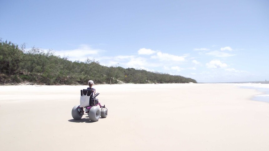 Jo drives along the sand of a pristine, empty beach in her specially designed chair.