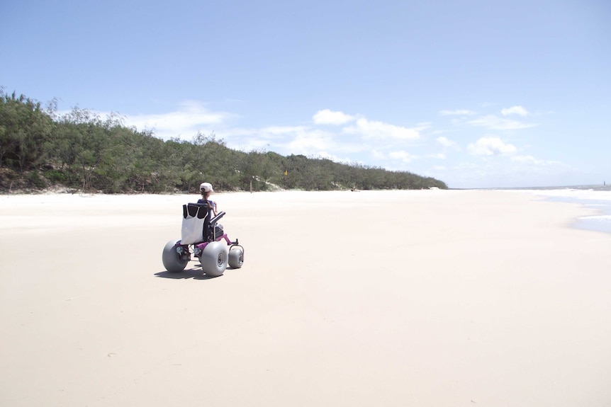 Jo drives along the sand of a pristine, empty beach in her specially designed chair.