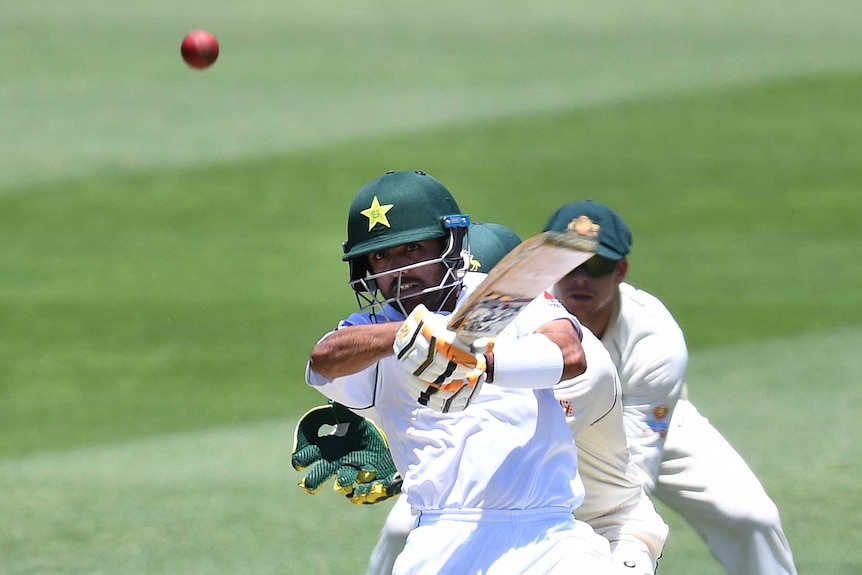 Pakistan batsman plays a pull shot while Tim Paine watches from behind the stumps.