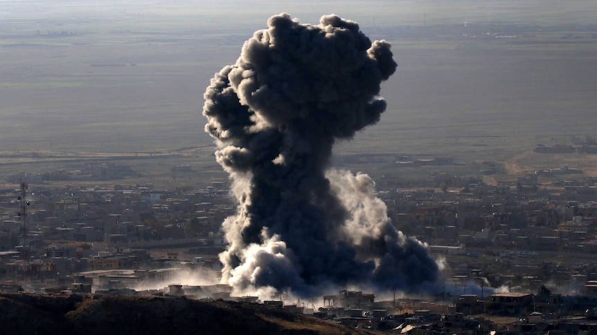 Heavy smoke billow out of the town of Sinjar.