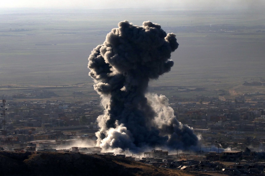 Heavy smoke billow out of the town of Sinjar.