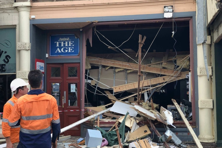 A shopfront that has been smashed in by a piece of heavy machinery.