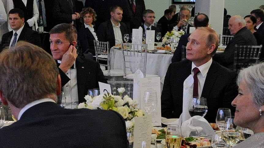 Vladimir Putin sits next Michael Flynn at the Russia Today exhibition.