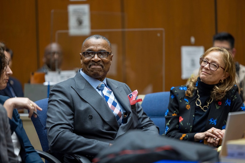 Maurice Hastings, in a grey suit, smiles in court 