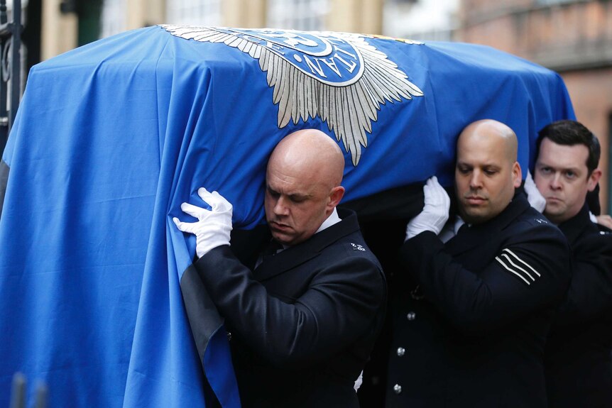 Pall bearers carry the coffin on PC Keith Palmer into Southwark Cathedral.