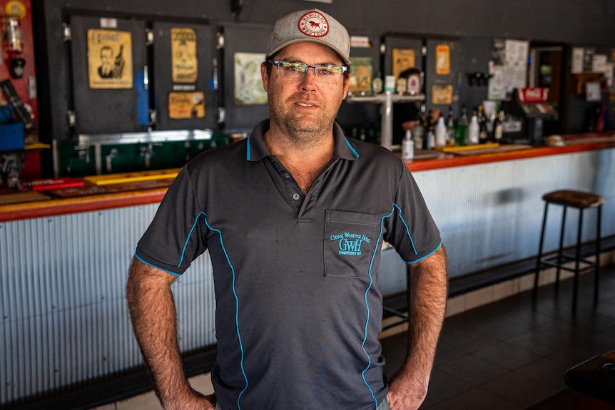 A pub owner stands in front of his bar