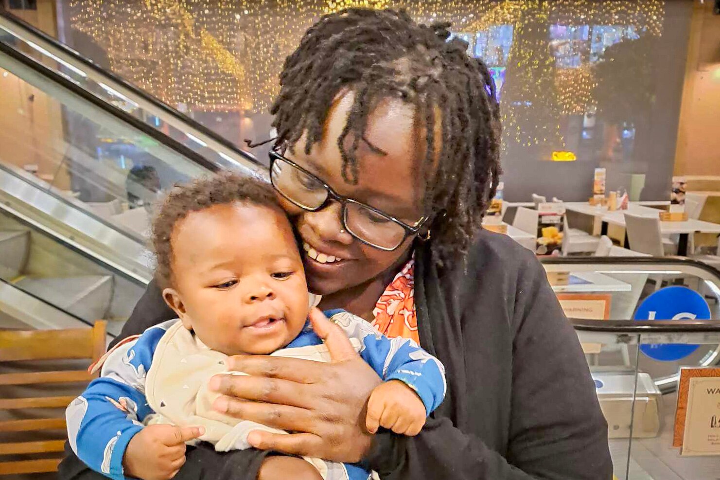 A woman and her son together, tightly cropped, laughing. 