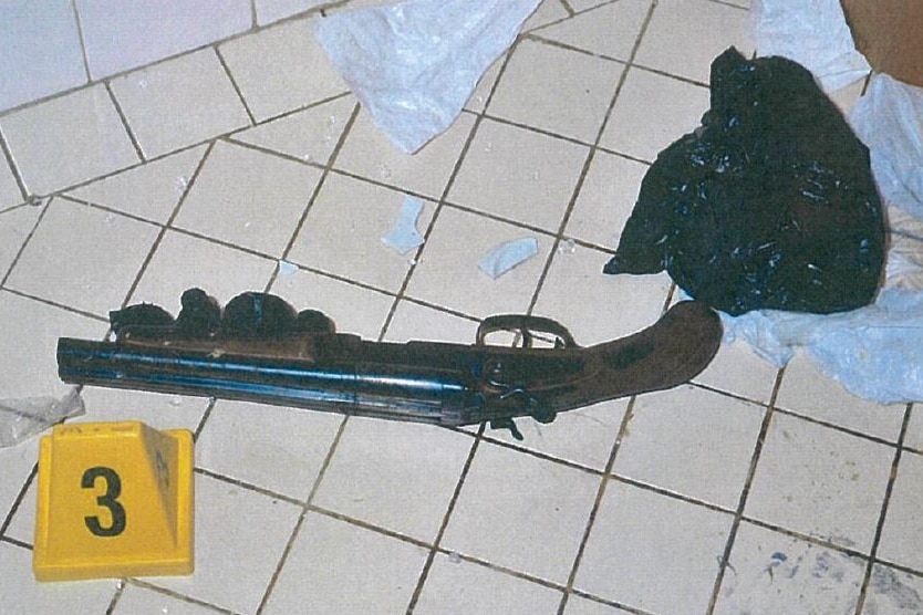 A long gun on a tiled floor