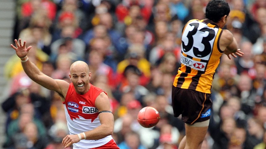 Cyril Rioli attempts to smother a kick from Jarrad McVeigh in the 2012 AFL Grand Final.
