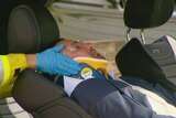 Salim Mehajer lying in his car with a neck brace on being attended by paramedics after a car accident in Lidcombe.