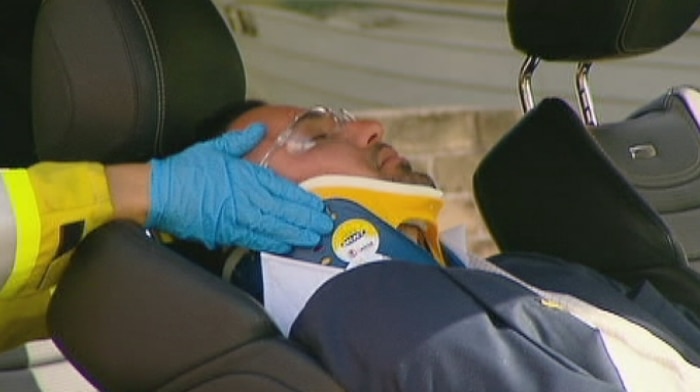 Salim Mehajer lying in his car with a neck brace on being attended by paramedics after a car accident in Lidcombe.