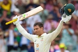 Australia batter Alex Carey raises his bat and helmet aloft after a century in the Boxing Day Test.