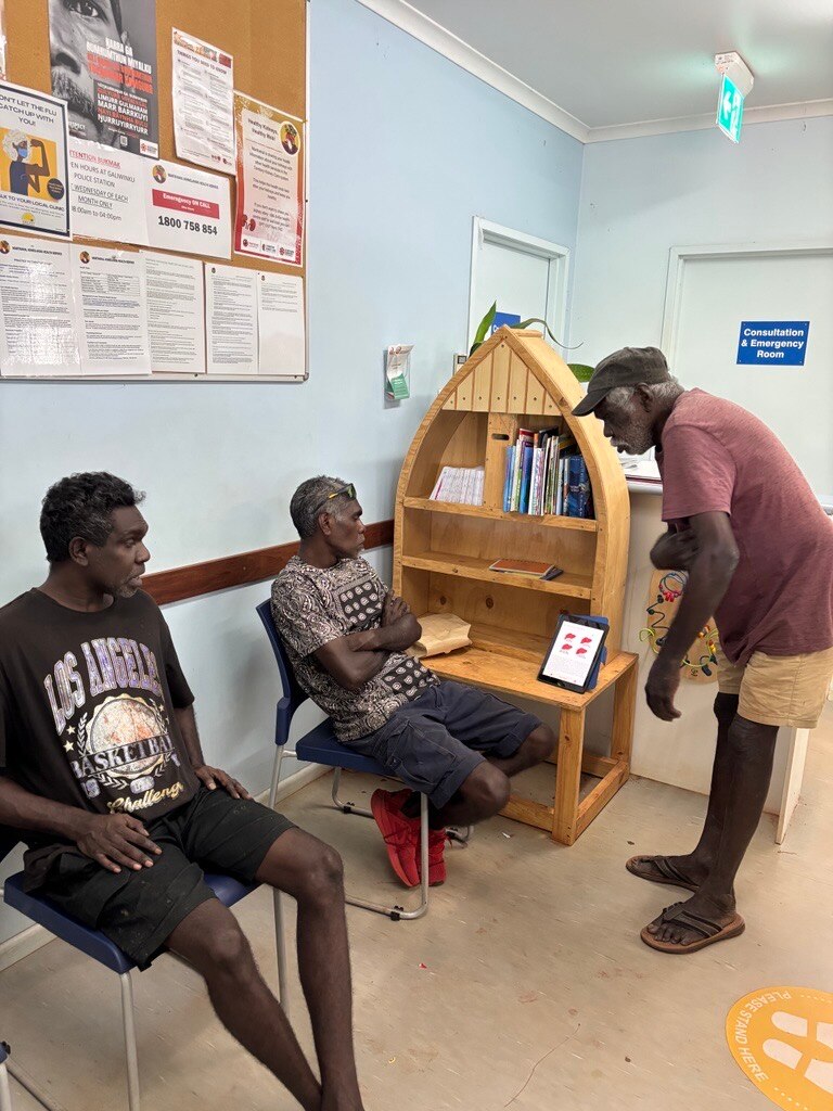 屋内で3人の先住民族の男性、2人がiPadにアプリを示しています。