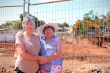 Two ladies standing in front of a house being demolished