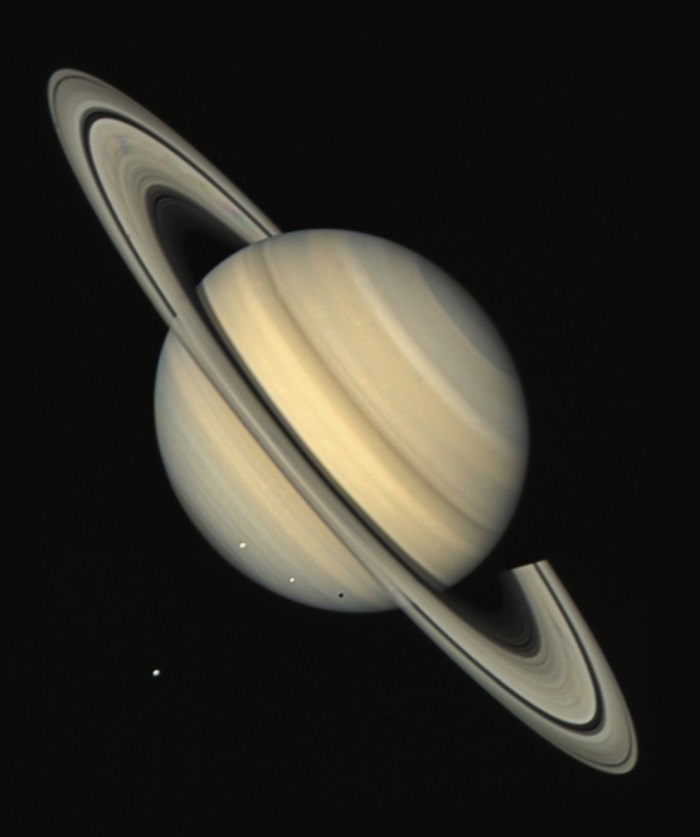 A view of the planet Saturn, on a tilt and brown-grey in colour