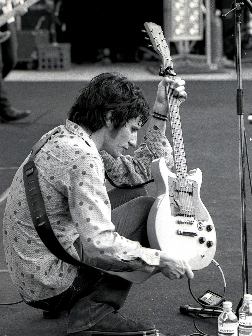 You Am I frontman Tim Rogers checks a guitar during the 1992 Big Day Out in Sydney.