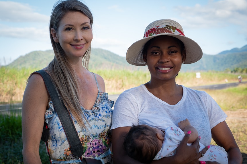 Two women with one of them holding a baby
