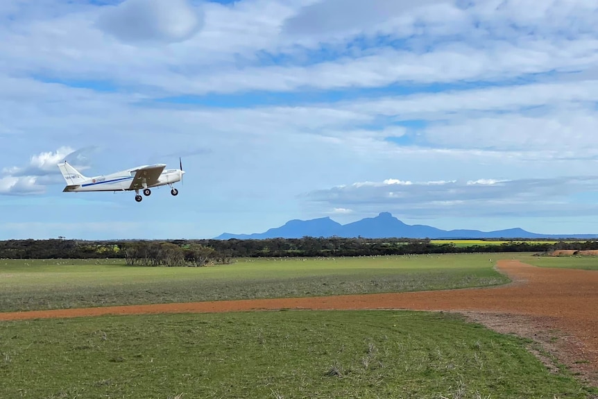 A plane is pictured taking off sideways, the Stirling Ranges are in the background