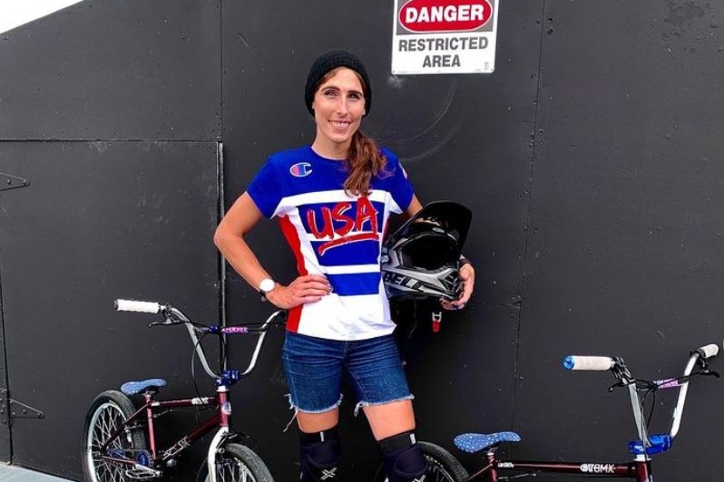 Chelsea Wolfe in her Team USA kit stands next to a BMX bike.