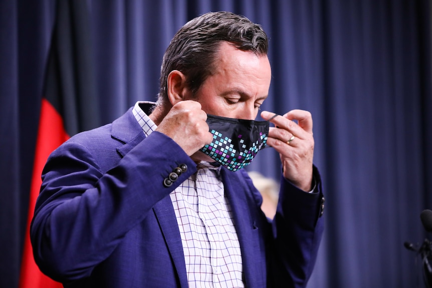 Mark McGowan taking his mask off.