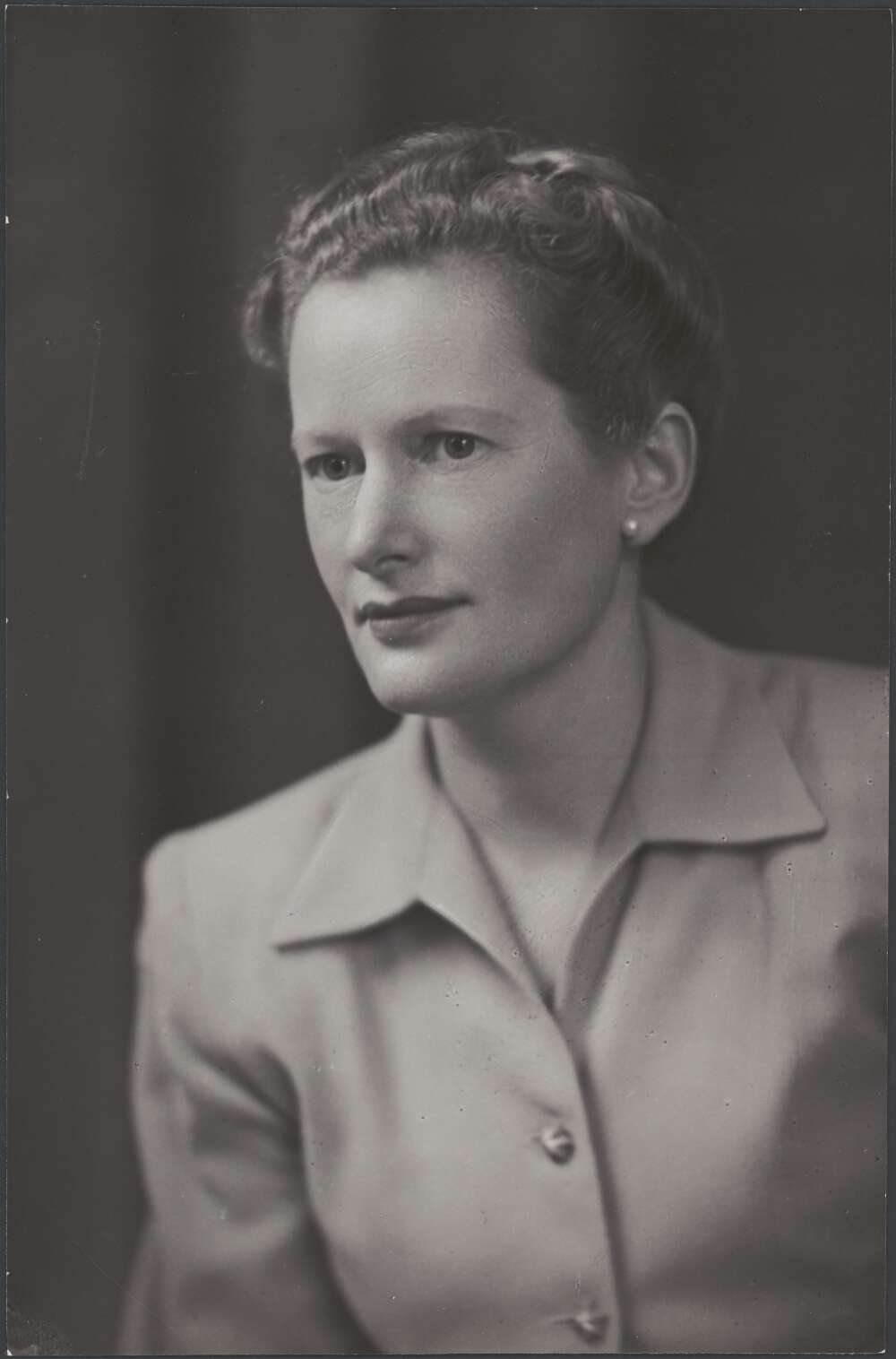 A black-and-white portrait of a young woman in a blouse.