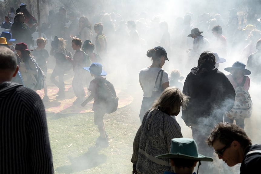 The crowd walks through the smoke