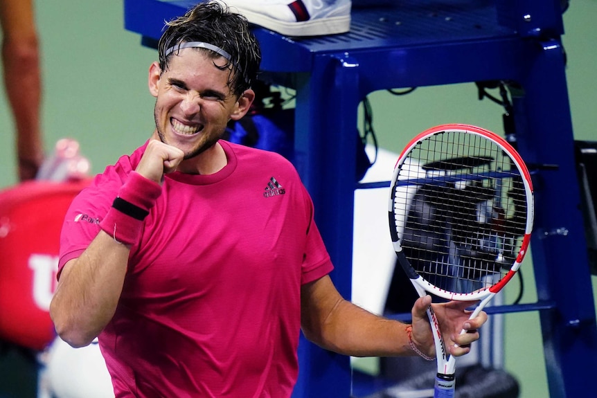 A tennis player grins as he clenches his fist near the umpire's chair after winning a US Open match.