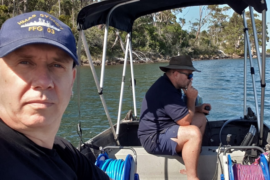 Jason Sallese with Diver Dan on a boat on a waterway.