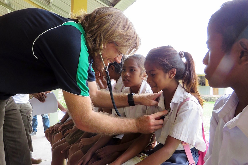 Dr Josh Francis examines children at a school in the regional district of Emera in East Timor.