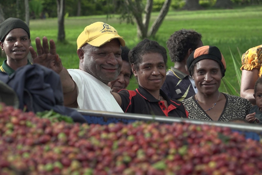 PNG coffee buyer Remdi Pena stands with a group of people.