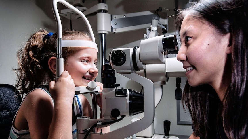Charlotte Gardner has her eyes tested by a QUT optometry student.