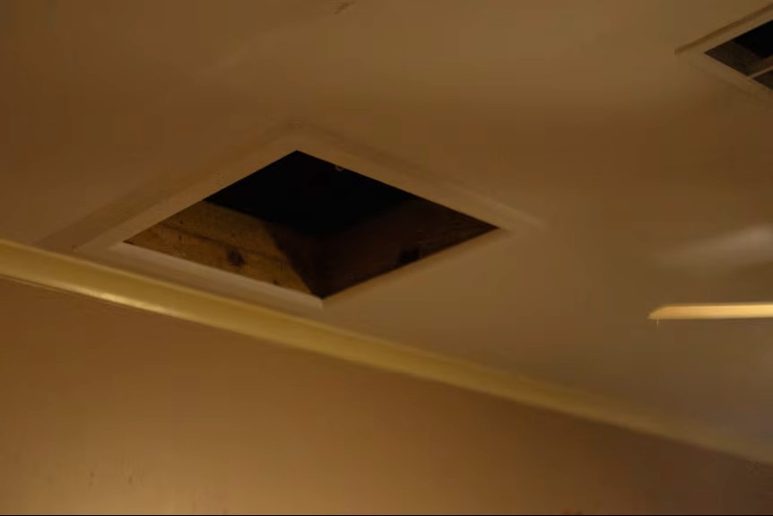 An open manhole in a ceiling. 