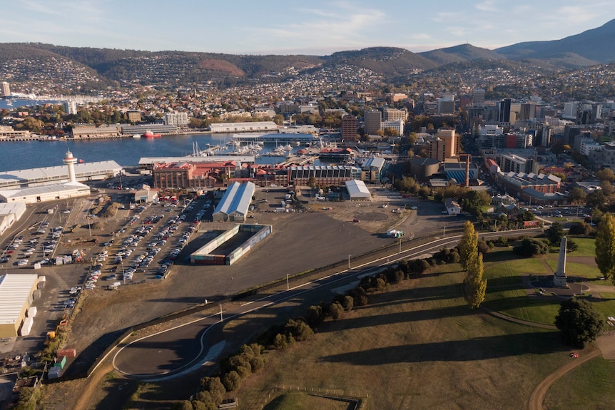 Port area of a city with buildings, cars and hills in the background