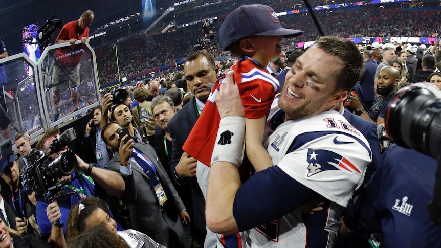 New England Patriots' Tom Brady lifts his son, Ben, after winning NFL Super Bowl LIII in Atlanta.