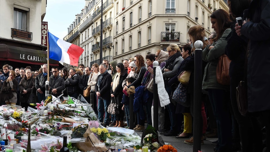 People observe a minute of silence on at Le Petit Cambodge restaurant.