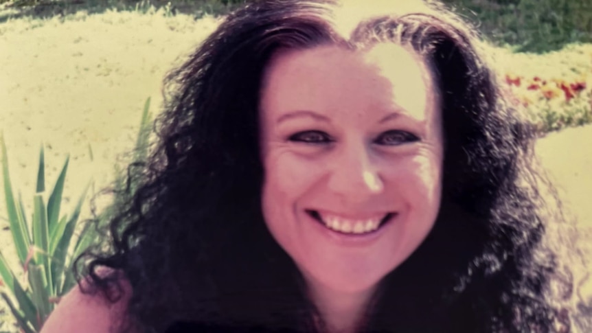 Kathleen Folbigg, as a younger woman with long dark hair, looks at the camera and smiles.