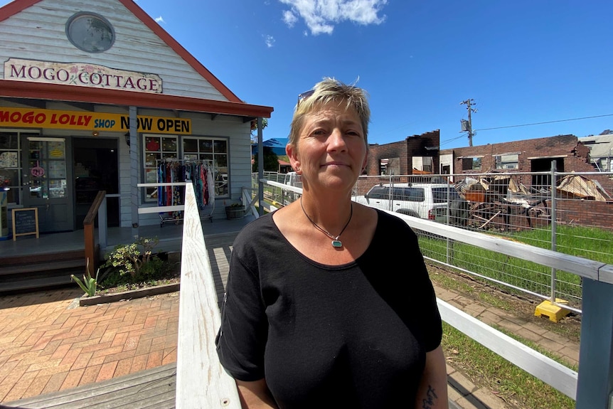 Theresa Matthews stands in front of a lolly shop cottage