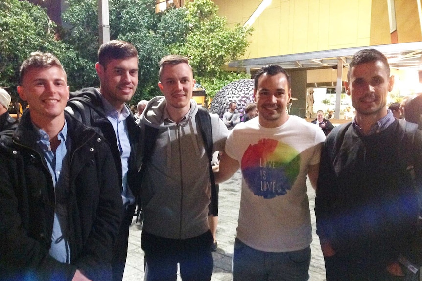 Five men link arms in support of the victims of the Orlando shooting.