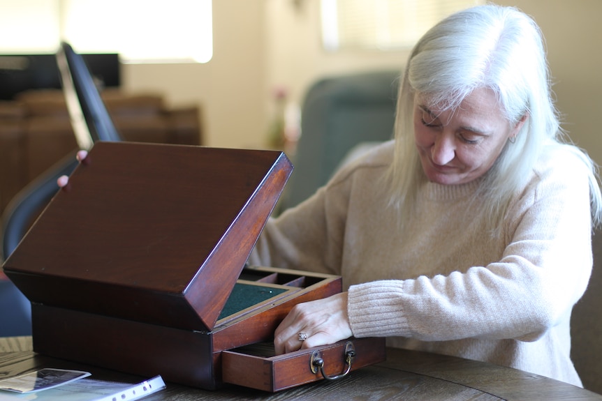 woman looking inside small wooden box