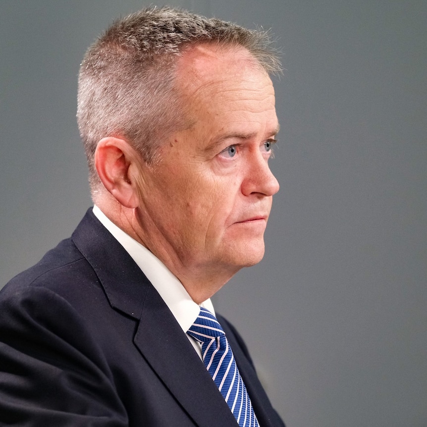 Bill Shorten, wearing a suit and tie in a grey room.