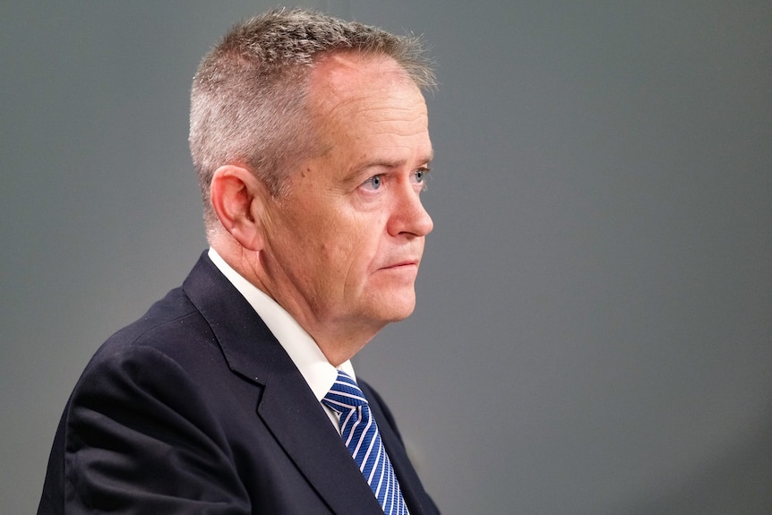 Bill Shorten, wearing a suit and tie in a grey room.