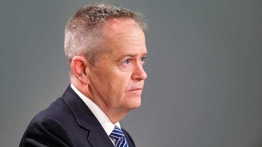 Bill Shorten, wearing a suit and tie in a grey room.